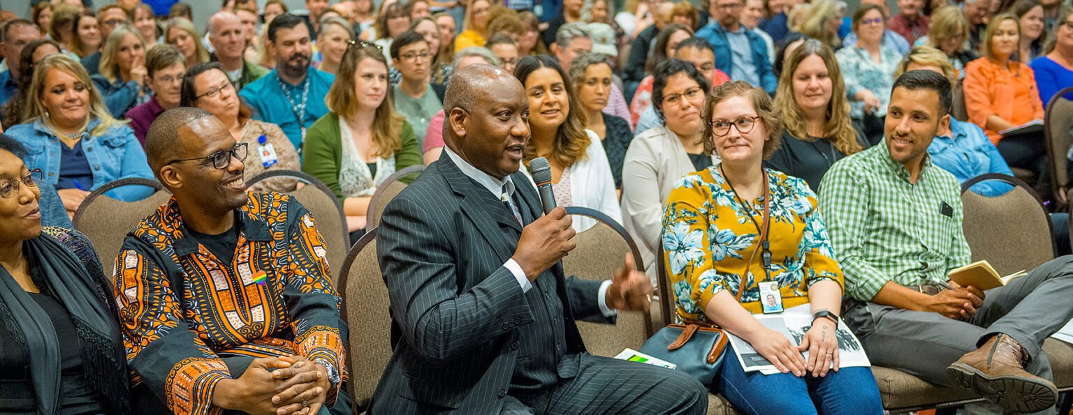 audience with a man holding a microphone