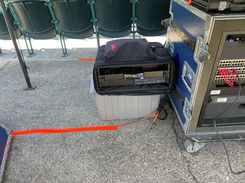 hearing loop driver on floor next to sound cart, with hearing loop wires extending from driver