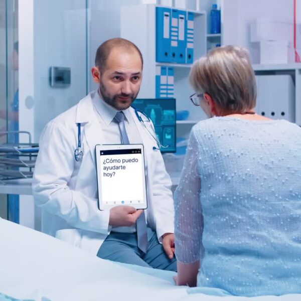 doctor speaking to patient while holding a tablet to translate speech to text.