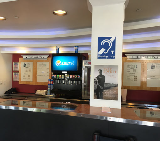 Photo of Avalon service counter showing hearing loop sign on post