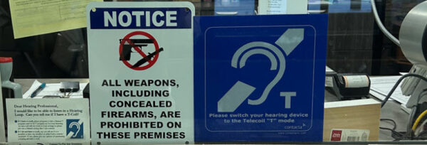 Sheriff security window with hearing loop sign, no firearms, about hearing loop