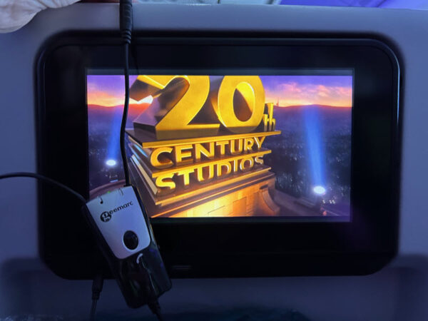 a Geemarc neckloop hanging off the corner of the airline entertainment (back of the seat)