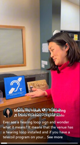 A women pointing to the hearing loop sign on the counter.