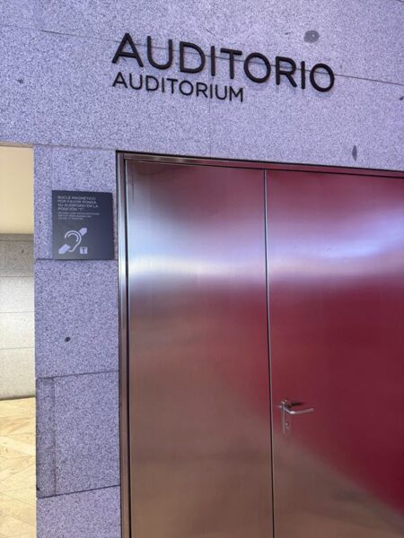 Auditorium doors with hearing loop sign to the left, at the Prado museum in Madrid