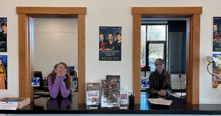 Ticket Office with two windows; each window has a blue sign telling patrons there is a hearing loop